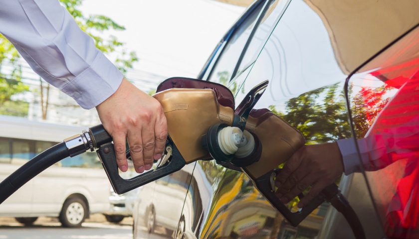 un home mettant du carburant dans une voiture