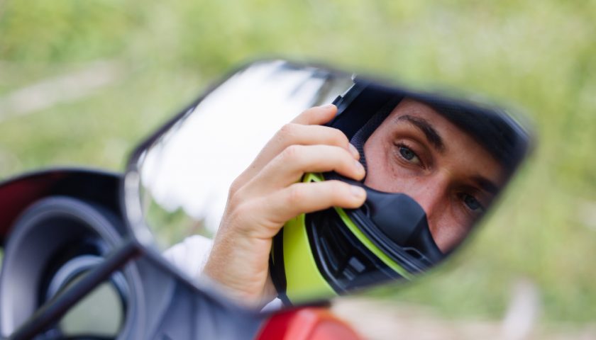 Motard qui se regarde dans le rétroviseur de sa moto
