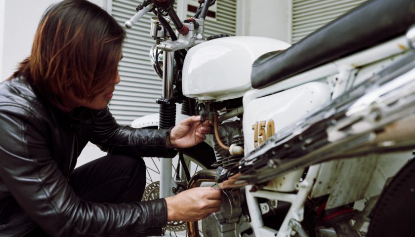 Homme vérifiant l'état d'une moto
