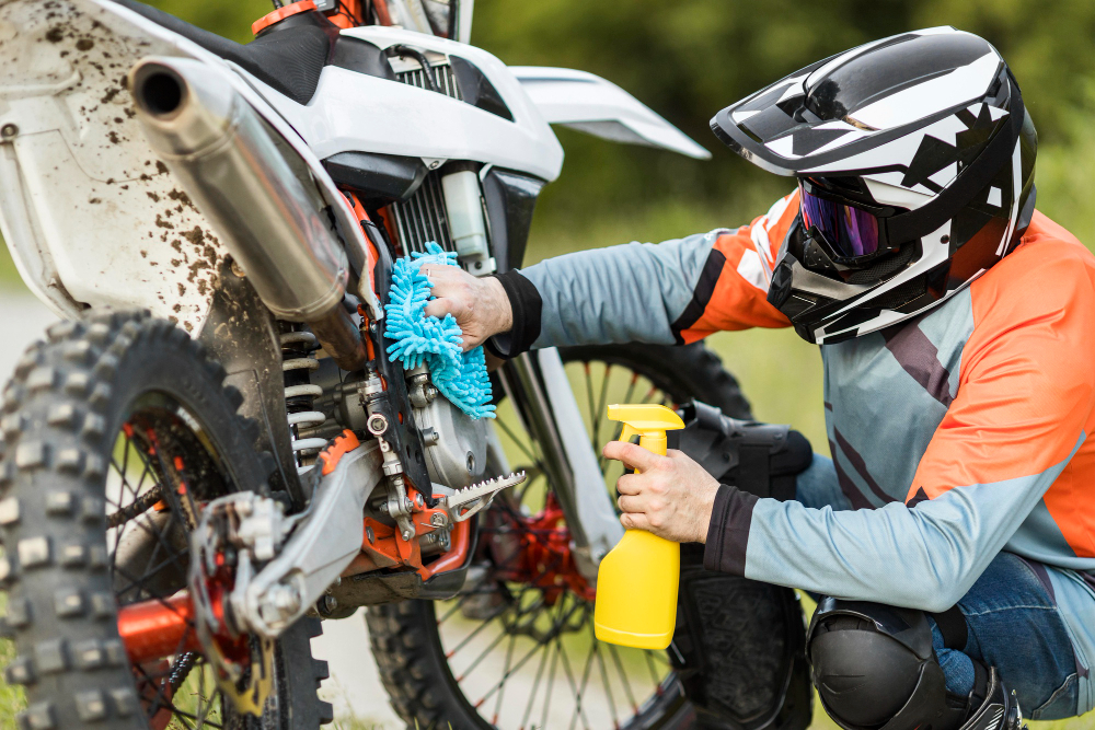 homme nettoyant sa moto cross