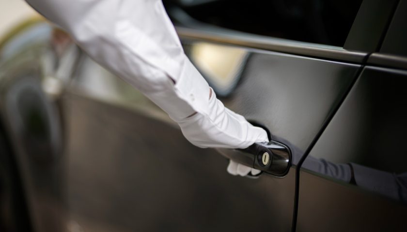 une personne ouvrant une portière avec des gants