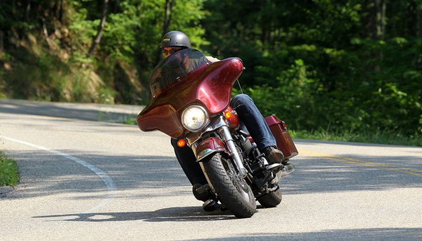 un homme conduisant une moto de tourisme rouge