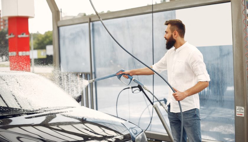 un homme lavant sa voiture à une station de lavage