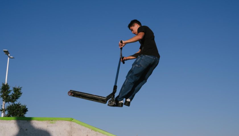 un jeune faisant du freestyle avec sa trotinette