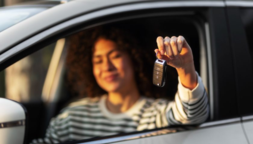 une femme a la fenetre de sa voiture brandissant sa clé