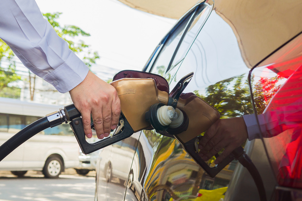 un home mettant du carburant dans une voiture