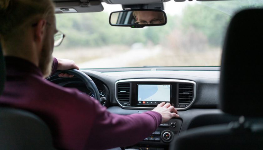 un homme règle l'écran de sa voiture