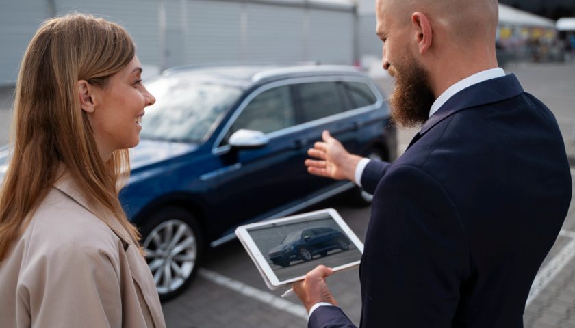 homme avec une tablette qui montre une voiture