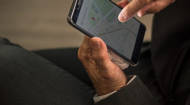 une homme regardant une carte GPS sur son téléphone portable