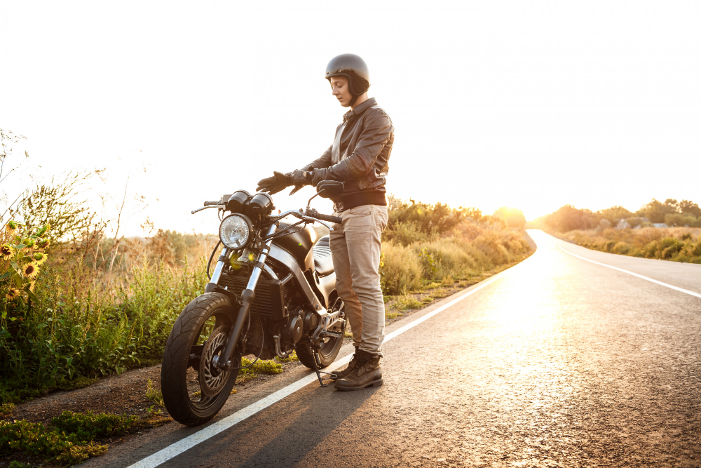 un homme avec sa moto sur la route
